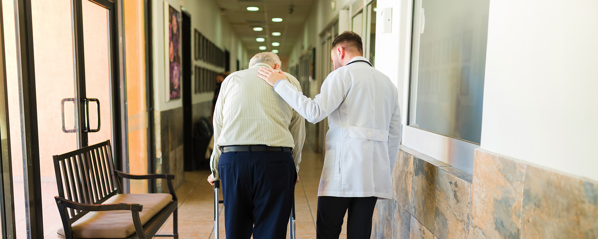 doctor and retired mature man taking a walk at the retirement home
