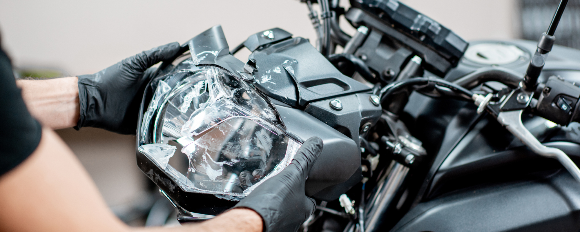 Worker repairing motorcycle headlight in the workshop