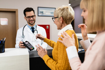 medical doctor charging patient with card reader