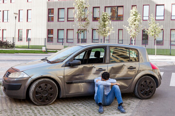 man on ground outside car accident