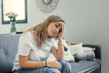 woman looking sad holding head