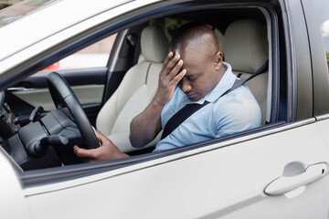 man with head down car accident