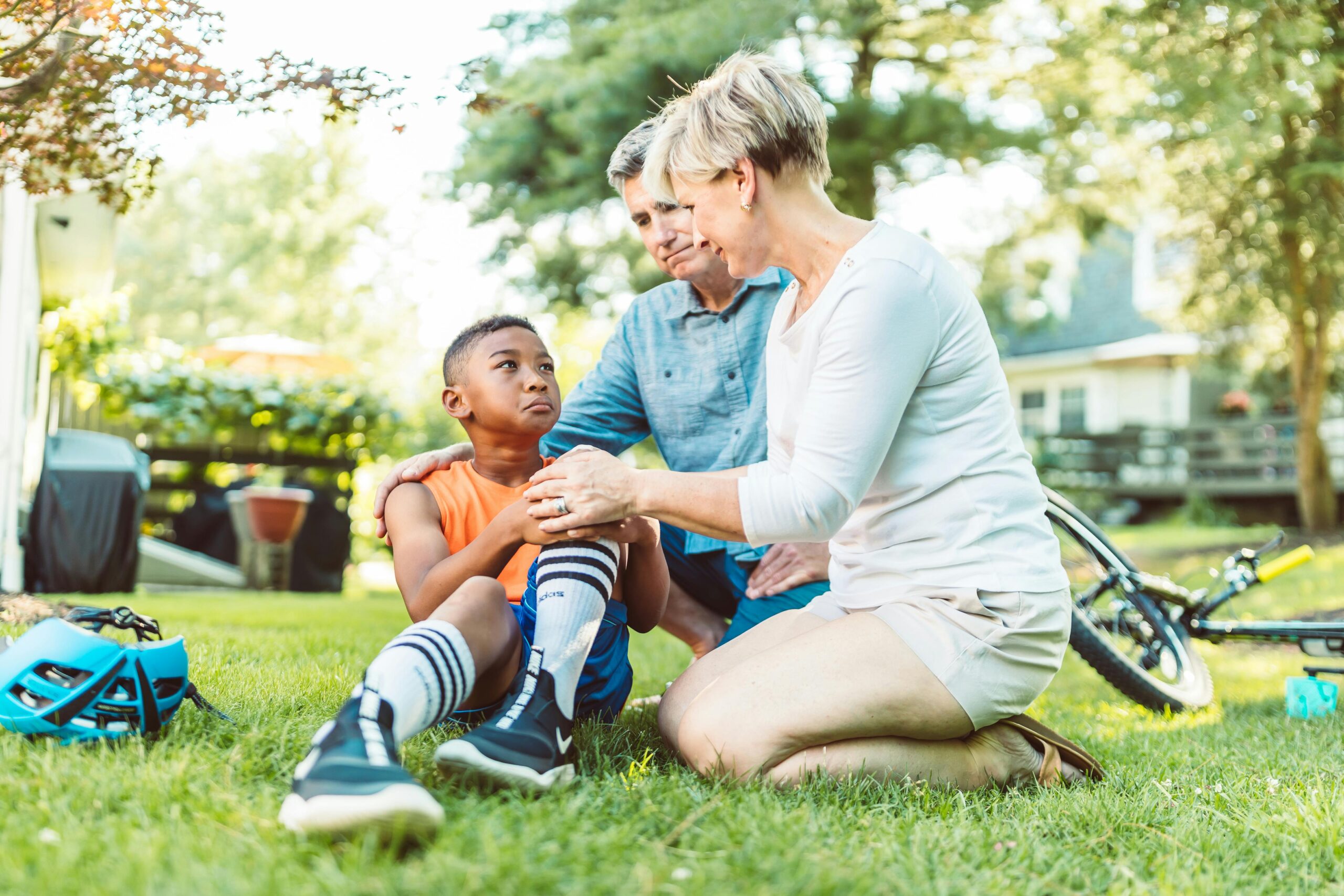 child with injured knee and adults around him